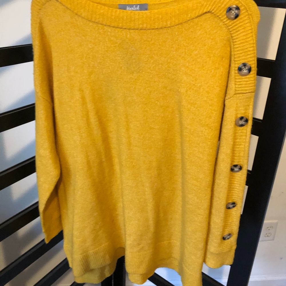 Yellow sweater with marbled button sleeve accent.